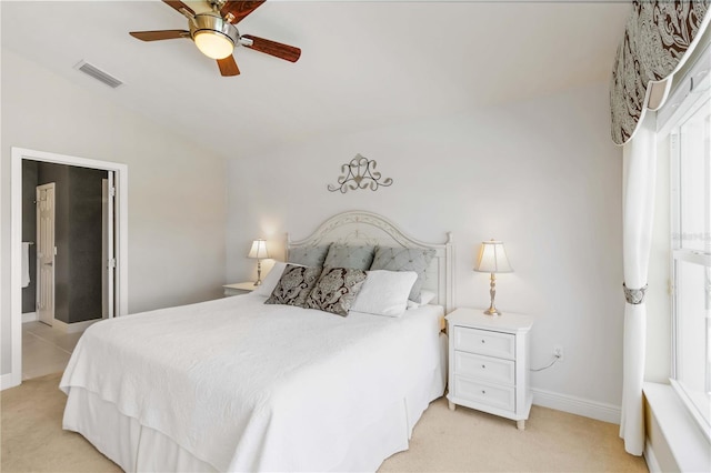 bedroom featuring visible vents, baseboards, lofted ceiling, multiple windows, and light colored carpet