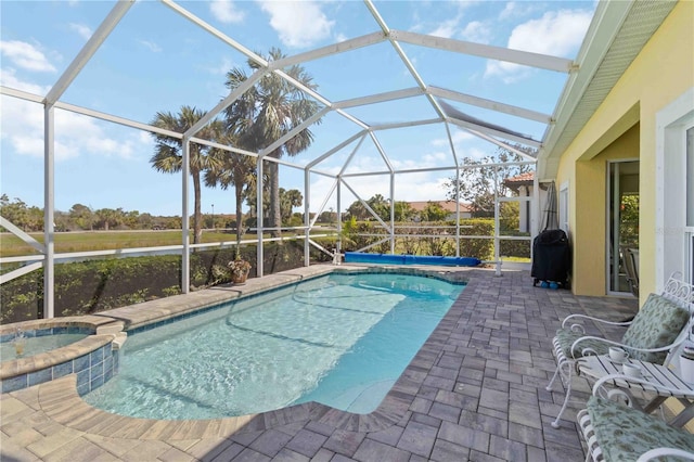 view of swimming pool with glass enclosure, a patio area, and a pool with connected hot tub