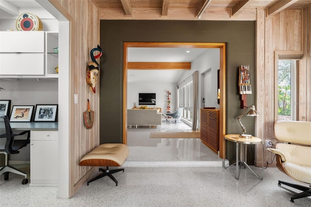 office space with a wealth of natural light, wooden walls, and beam ceiling