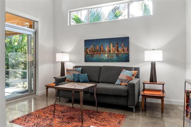 living room featuring concrete floors and a towering ceiling