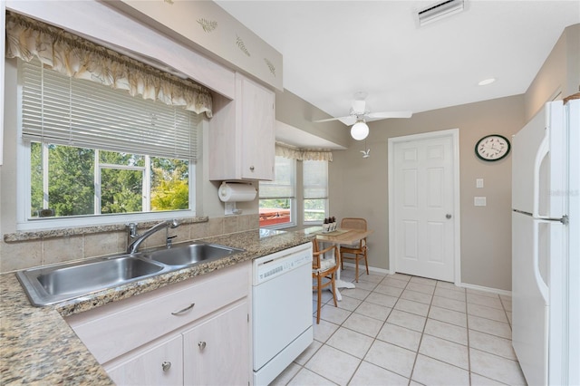 kitchen featuring light tile patterned floors, white appliances, a sink, visible vents, and baseboards