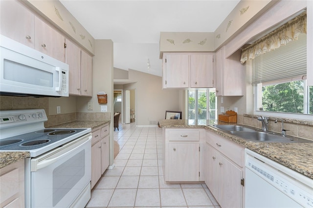 kitchen with white appliances, light tile patterned floors, baseboards, light countertops, and a sink