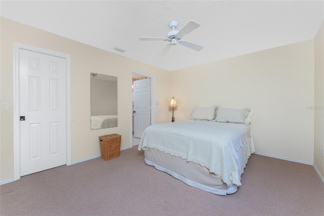 carpeted bedroom with visible vents, a ceiling fan, and baseboards