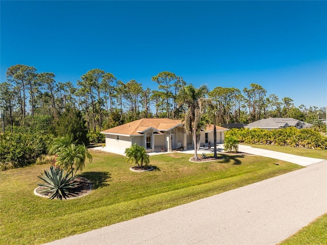 view of front of property featuring an attached garage, a front lawn, concrete driveway, and stucco siding