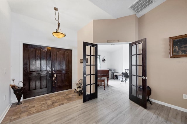 foyer featuring baseboards, french doors, visible vents, and light wood-style floors