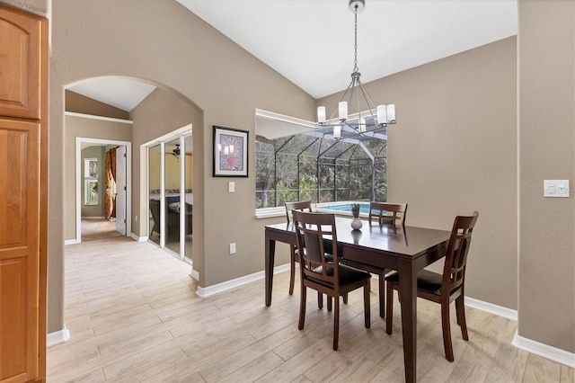 4050 Rock Creek Dr, Port Charlotte, FL 33948 - dining room with arched walkways, lofted ceiling, light wood-style flooring, a chandelier, and baseboards
