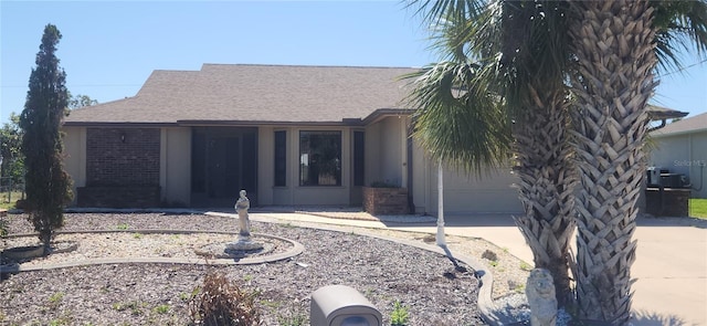 view of front facade with concrete driveway, brick siding, an attached garage, and roof with shingles