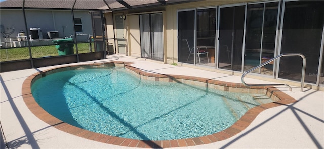 pool featuring glass enclosure and a patio