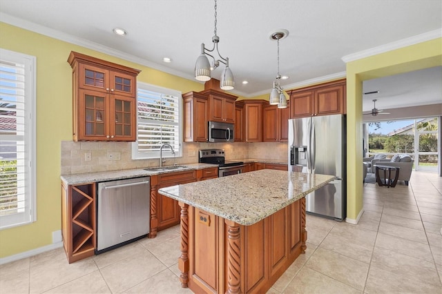 kitchen featuring decorative light fixtures, stainless steel appliances, a kitchen island, a sink, and glass insert cabinets