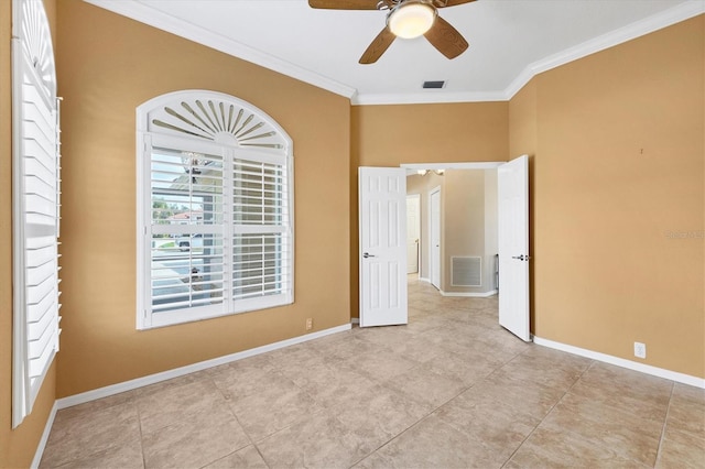 unfurnished room featuring baseboards, visible vents, and ornamental molding