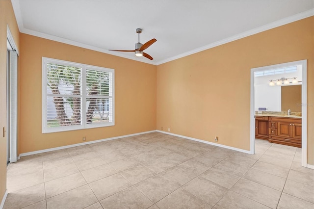 unfurnished bedroom with baseboards, ornamental molding, ensuite bathroom, a sink, and light tile patterned flooring