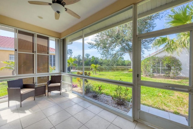 sunroom with a water view and ceiling fan