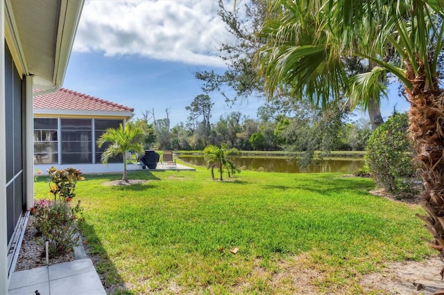 view of yard with a water view and a sunroom