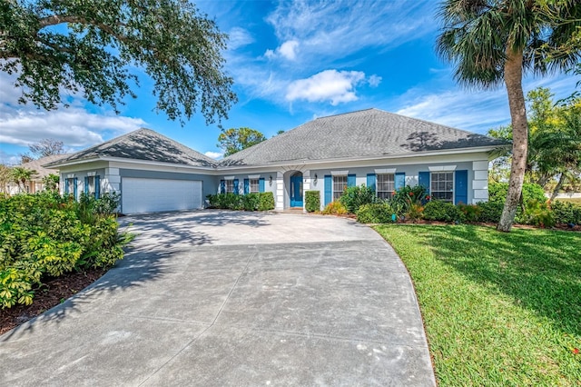 single story home with a garage, stucco siding, concrete driveway, and a front yard