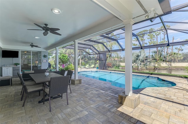 pool with ceiling fan, glass enclosure, outdoor dining space, and a patio