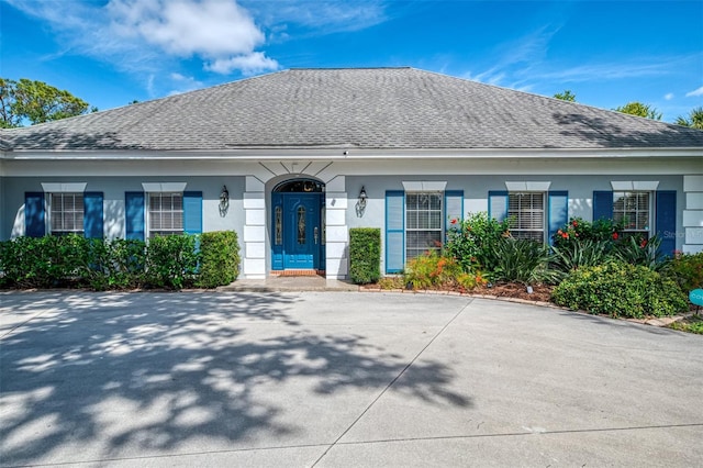 view of front of property with roof with shingles and stucco siding