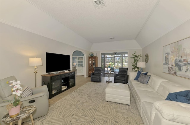 living area featuring vaulted ceiling, a textured ceiling, and visible vents