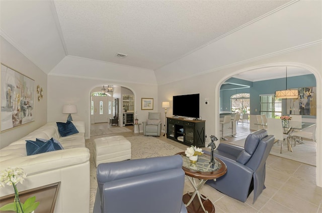 living area with light tile patterned floors, visible vents, arched walkways, vaulted ceiling, and crown molding