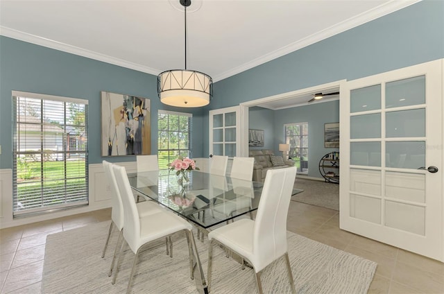 dining room featuring ornamental molding, a wainscoted wall, and light tile patterned floors