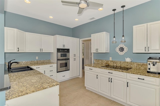 kitchen with hanging light fixtures, double oven, white cabinets, a sink, and black electric cooktop