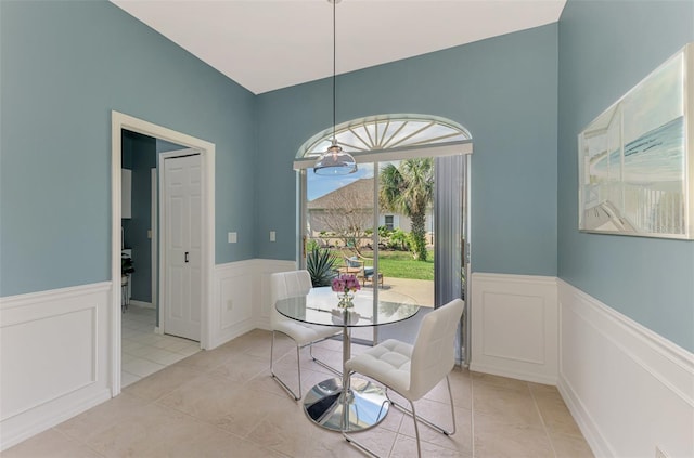 dining area with wainscoting and light tile patterned floors