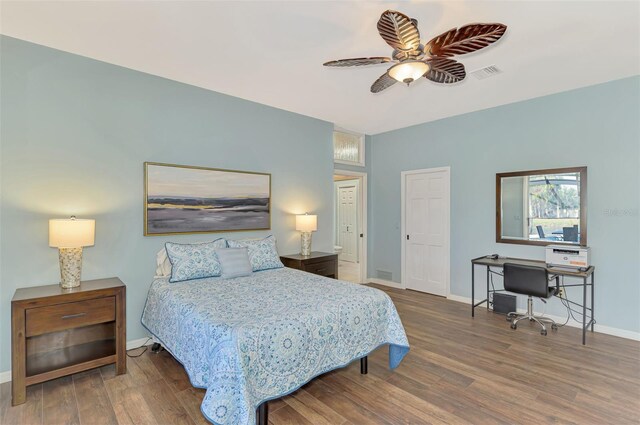 bedroom featuring visible vents, dark wood finished floors, baseboards, and ceiling fan