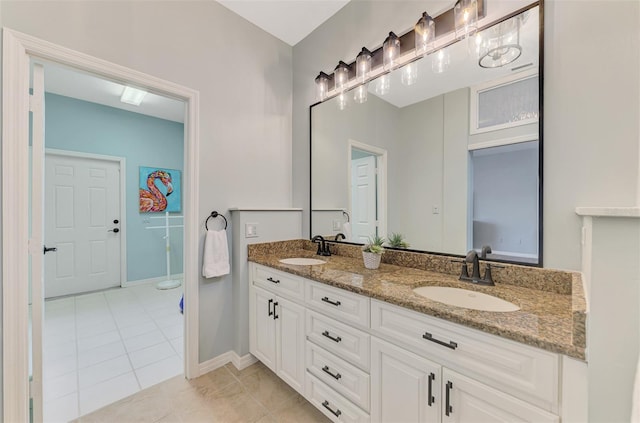 full bathroom with double vanity, baseboards, a sink, and tile patterned floors