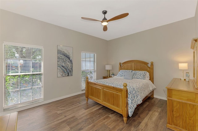 bedroom with dark wood-style floors, ceiling fan, multiple windows, and baseboards