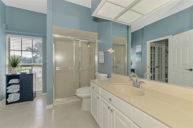 bathroom with toilet, a stall shower, vanity, and tile patterned floors