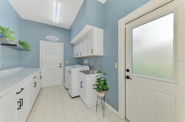 laundry room with cabinet space, baseboards, washing machine and clothes dryer, a sink, and light tile patterned flooring