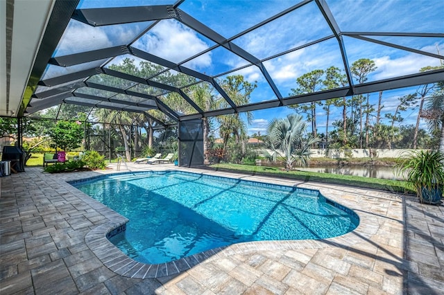 pool featuring a patio area, glass enclosure, and a water view