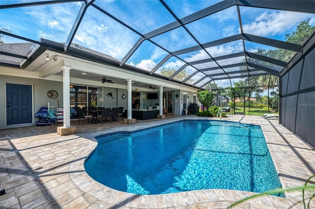 outdoor pool with glass enclosure, a patio area, an outdoor hangout area, and a ceiling fan