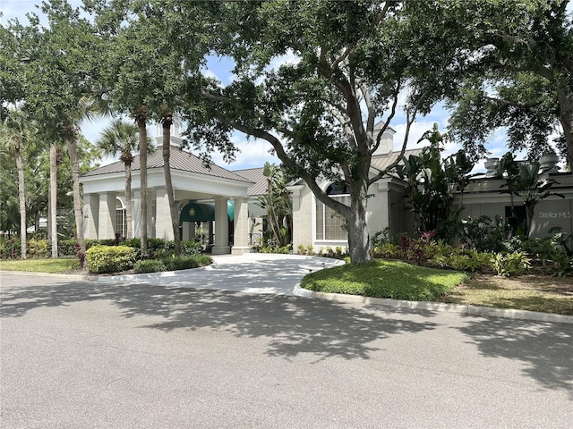 view of front of home with driveway, metal roof, and stucco siding