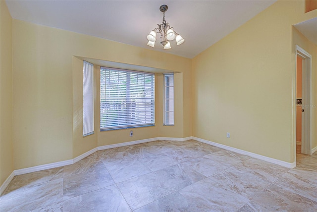 empty room with lofted ceiling and a chandelier