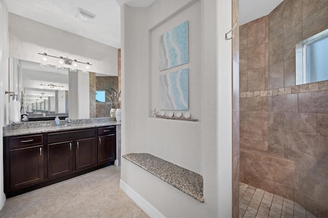 full bath with tile patterned flooring, visible vents, vanity, baseboards, and walk in shower