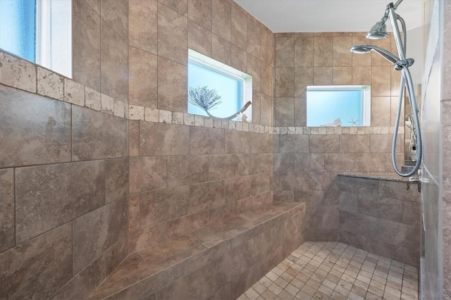 bathroom with tiled shower and a wealth of natural light