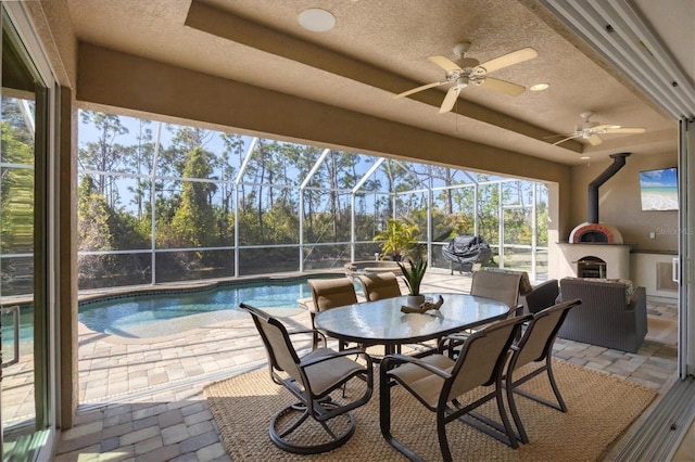 sunroom / solarium featuring a tray ceiling and a wood stove