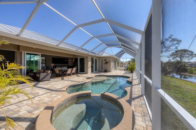 view of swimming pool featuring a pool with connected hot tub, glass enclosure, and a patio