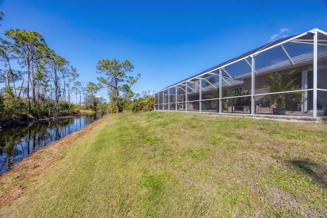 view of yard featuring glass enclosure and a water view