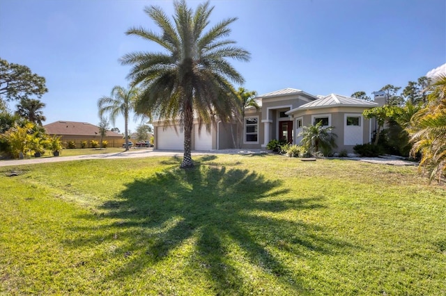 view of front of house featuring a front lawn, a standing seam roof, an attached garage, and concrete driveway