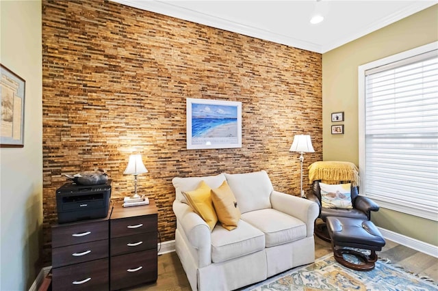 living area with baseboards, crown molding, and wood finished floors