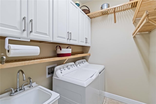 laundry room featuring cabinet space, baseboards, a sink, and independent washer and dryer