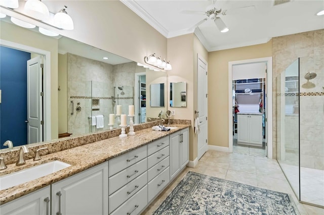 bathroom with a walk in closet, crown molding, double vanity, a sink, and walk in shower