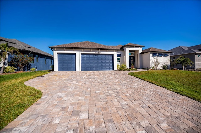 prairie-style house with a front lawn, decorative driveway, an attached garage, and stucco siding