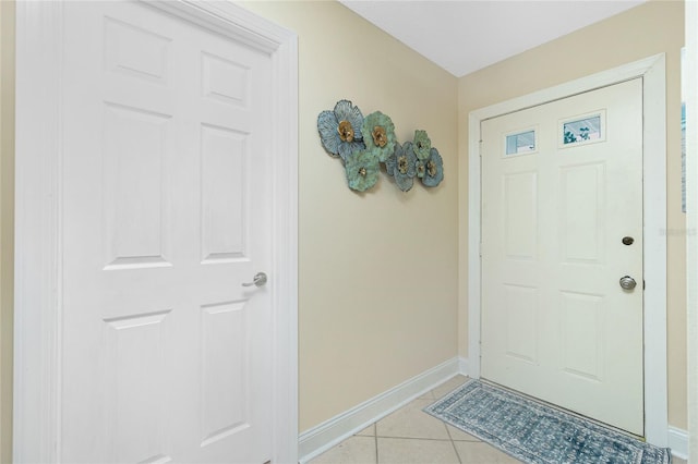 foyer with light tile patterned flooring and baseboards