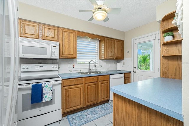 kitchen with light tile patterned flooring, white appliances, a sink, tasteful backsplash, and brown cabinetry