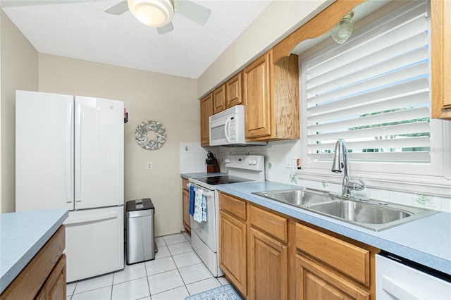 kitchen with white appliances, light countertops, a sink, and light tile patterned floors