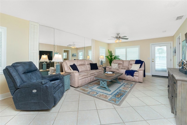 living area featuring a ceiling fan, visible vents, baseboards, and light tile patterned floors