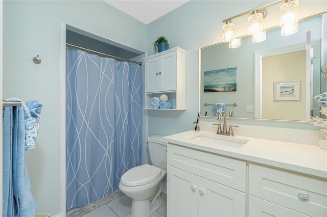 bathroom with toilet, vanity, and tile patterned floors