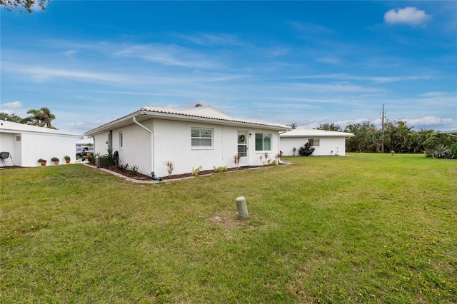 back of property featuring a yard and stucco siding